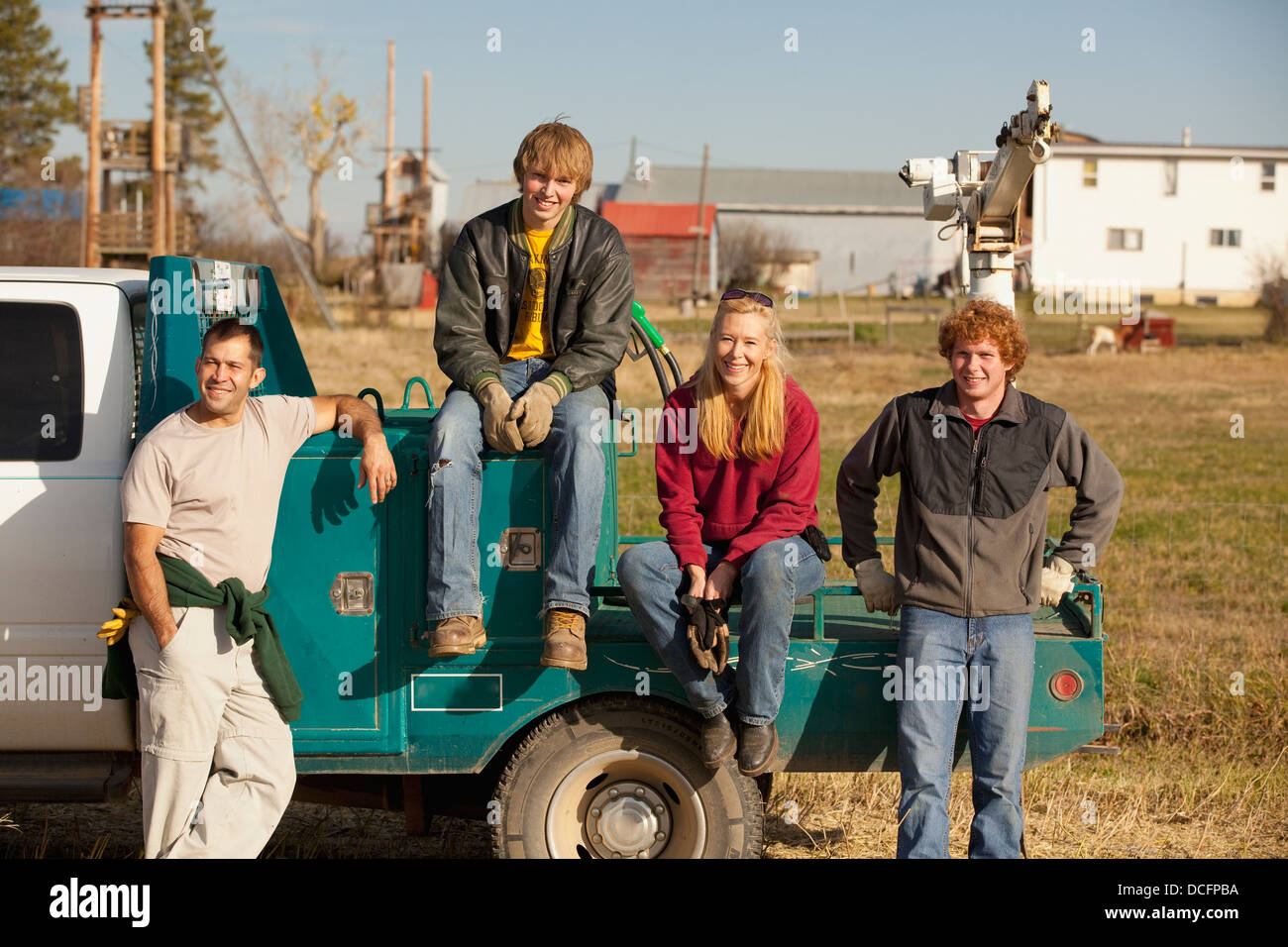 Un grupo de personas sentadas en la parte trasera de un camión; tres colinas, Alberta, Canadá Foto de stock