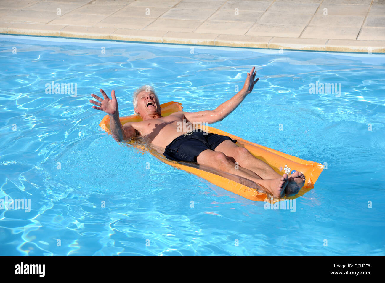 El hombre tomando el sol sobre una colchoneta en una piscina en casa rural  en la región de Lot o departamento del Sur Oeste de Francia Fotografía de  stock - Alamy