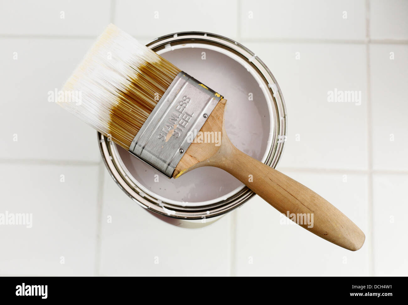 Pincel y abrir una lata de pintura blanca Fotografía de stock - Alamy