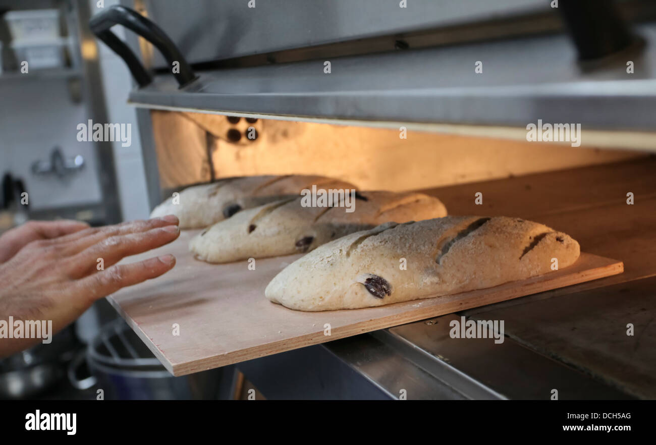 Se pone el pan en un horno para cocer en una panadería Fotografía de stock  - Alamy