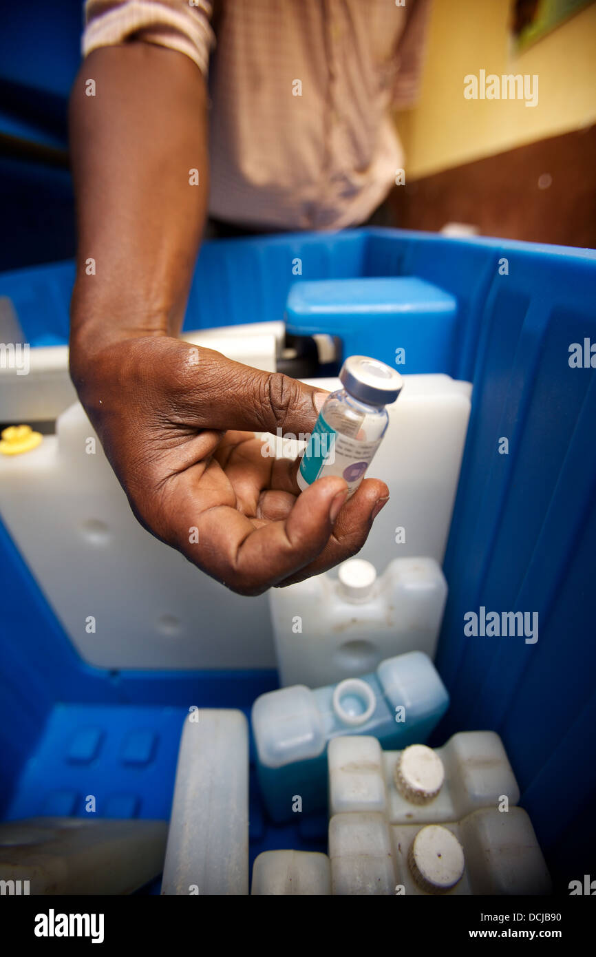 Mano sujetando vial de vacuna antitetánica extraído de la caja de refrigeración, Tanzania. Foto de stock