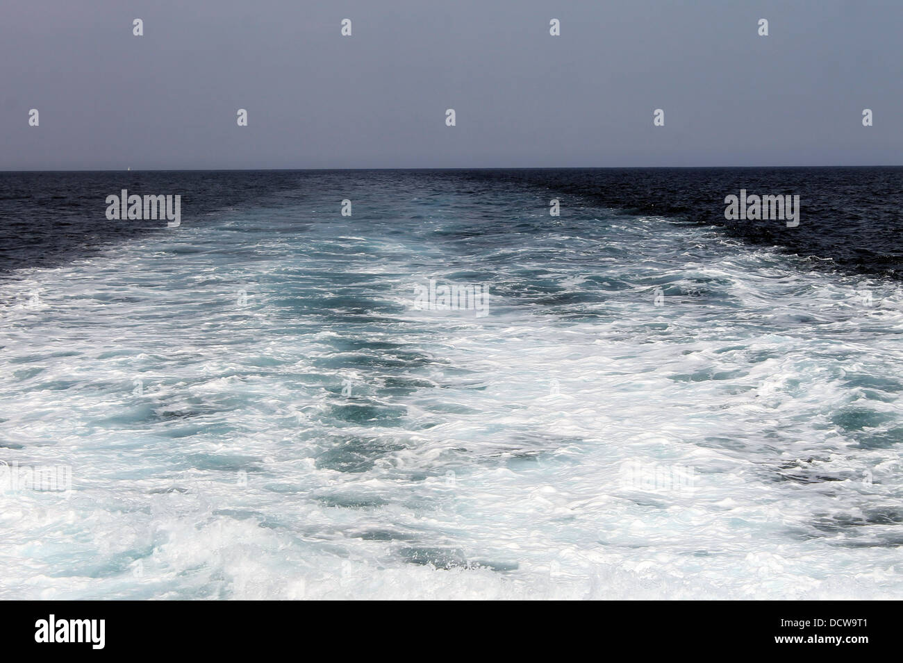 Estela turbulenta de barco navegando en el mar azul. Foto de stock