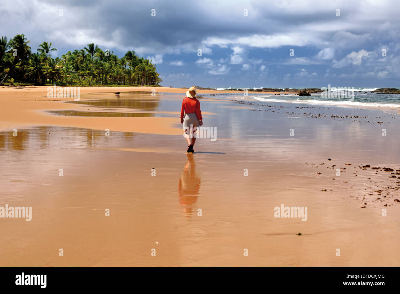 Brasil, Bahia: Turista mujer caminando a la playa Praia Busca Vida en Camacari cerca del Salvador Foto de stock