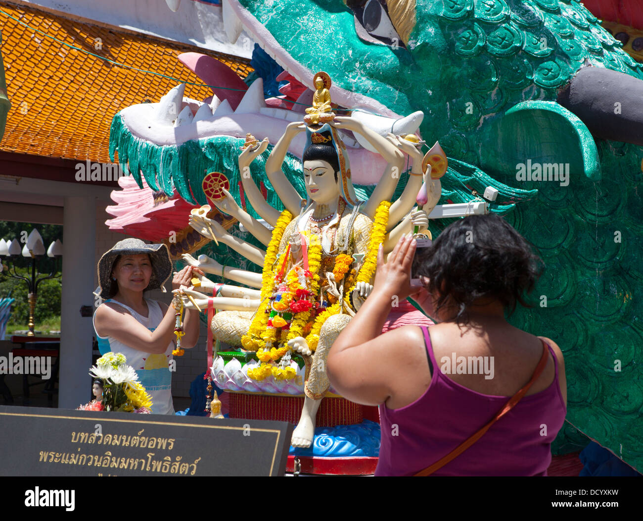 Los visitantes a una estatua de Buda en Wat Plai Laem en Ko Samui Island en el Golfo de Tailandia. Foto de stock