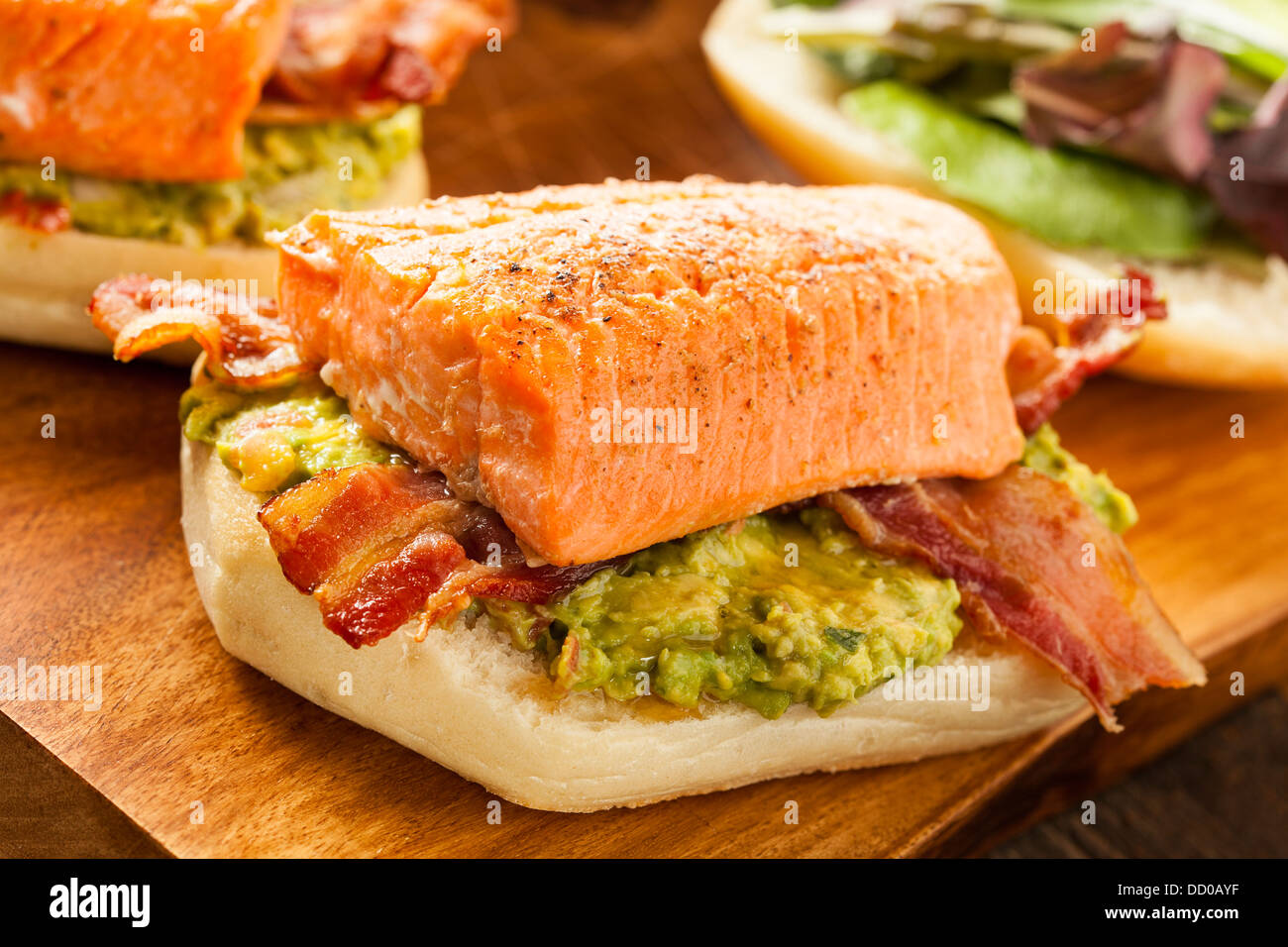 Sándwich de salmón a la parrilla con bacon y Guacamole sobre pan Foto de stock