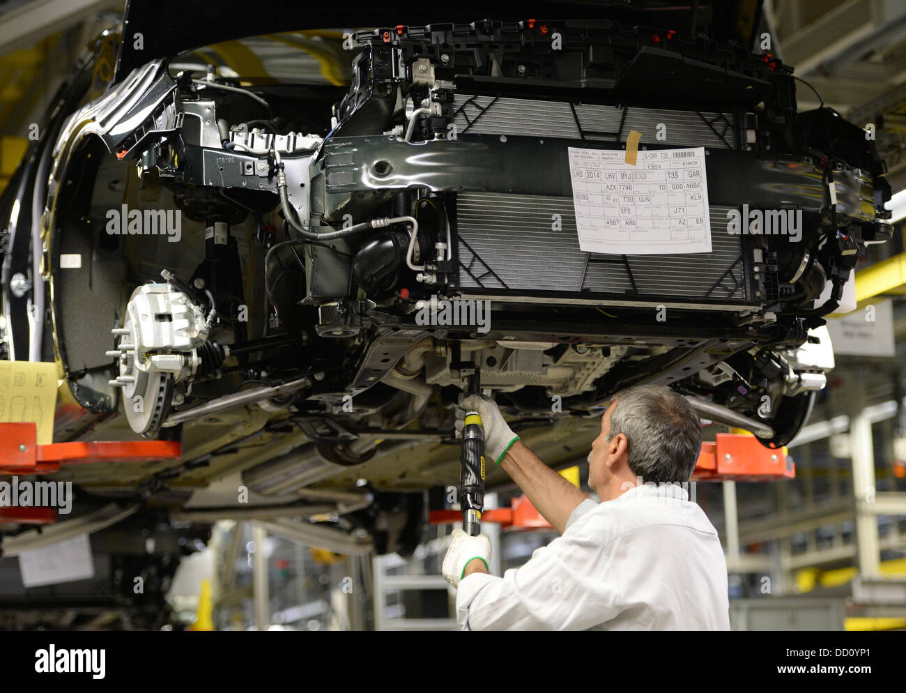 Un empleado de Opel tornillos piezas en diferentes modelos de coches en la producción en la planta principal de Opel en Russelsheim, Alemania, 22 de agosto de 2013. Foto: Arne Dedert Foto de stock