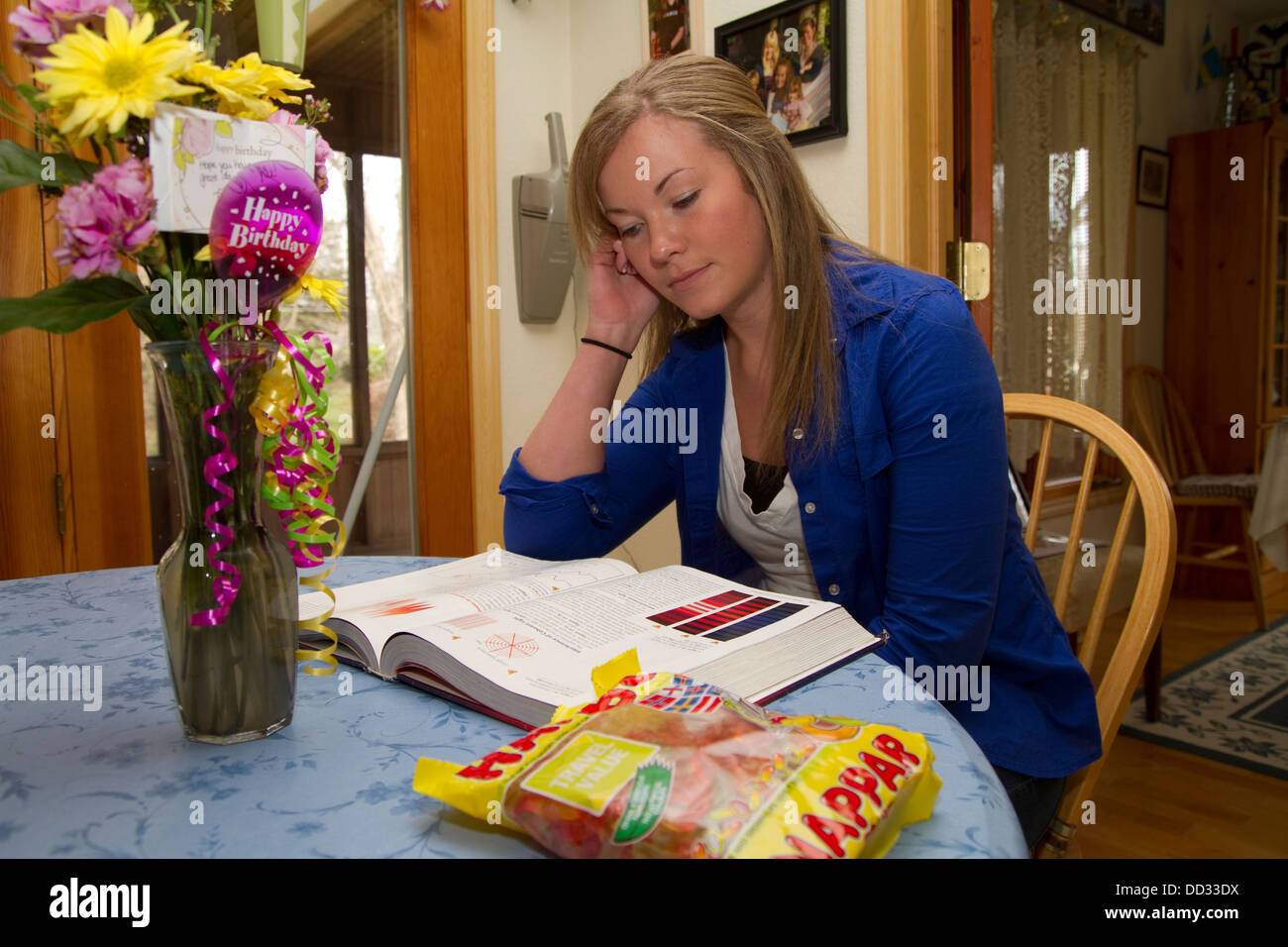 Joven estudiante en la mesa de la cocina haciendo los deberes. Lindsborg, Kansas. Foto de stock