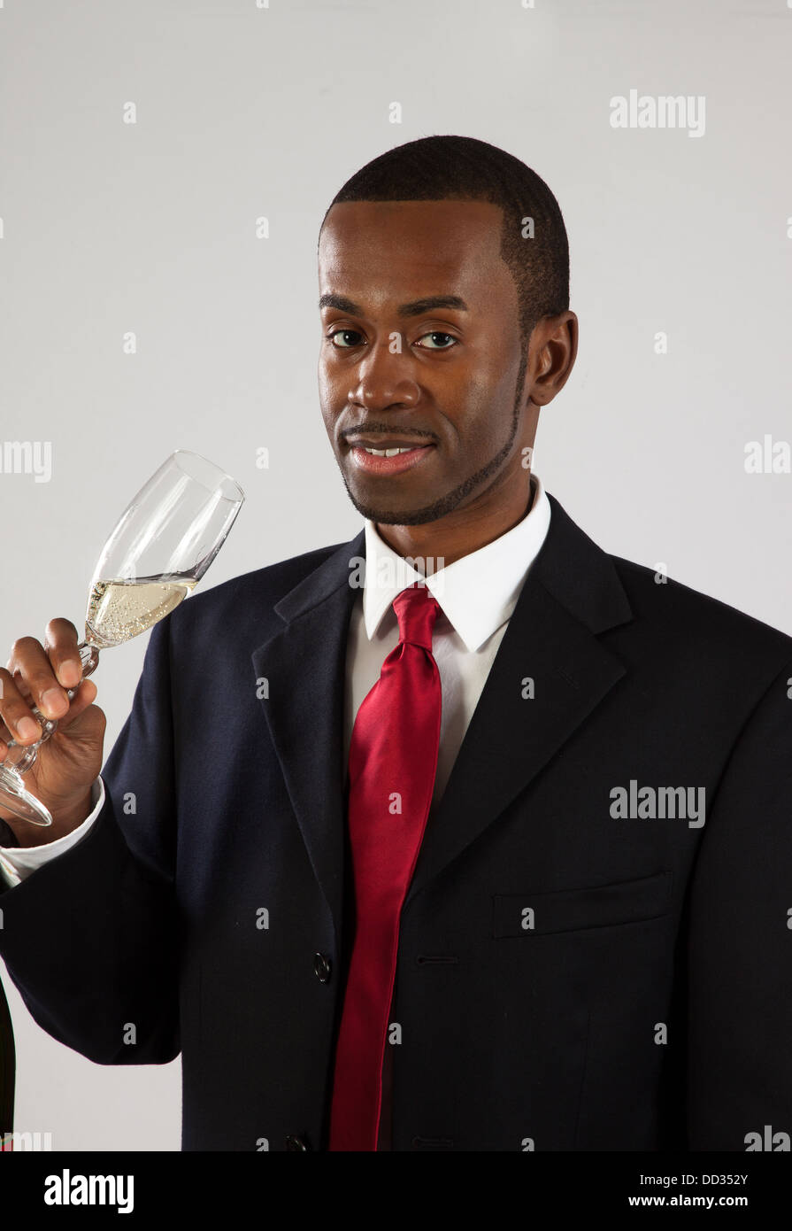 Apuesto hombre negro en un traje y corbata roja, sosteniendo una copa de  vino y mirando la cámara Fotografía de stock - Alamy