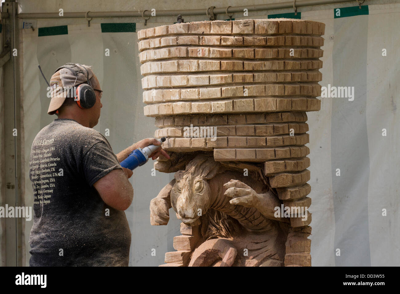 Tabley, Cheshire, Reino Unido, 25 de agosto, 2013. Steven Kenzora desde Canadá en la 9ª Inglesa Abierto Chainsaw Carving competencia, Cheshire County Showground, Juego y Feria del Condado, Tabley, Nr Knutsford, Reino Unido. La motosierra talladores de madera de uso (a veces enormes bits) para producir hermosas tallas de hasta 20 pies de altura. Cuando cada uno se convierte en una obra de arte buscado después de escultura en madera, serrín, escultor, madera, astillas, registro, profesionales, laborales, arte, artista, cortar, sierra de cadena, obras de arte hechas de madera áspera log. Foto de stock
