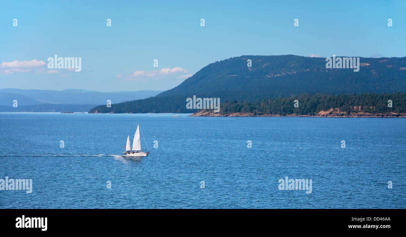 Disparo desde la cubierta de un Ferry BC mientras viaja entre Vancouver y Victoria. Mayne Island se pueden ver detrás de un velero. Foto de stock