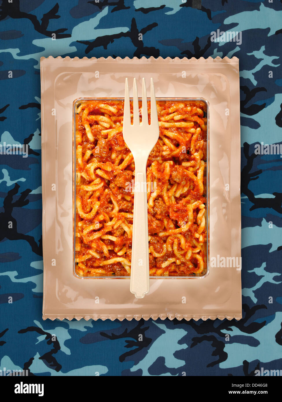 Raciones militares o MRE comidas listas para comer en un fondo camuflado. Los paquetes abiertos con utensilios de plástico. Foto de stock