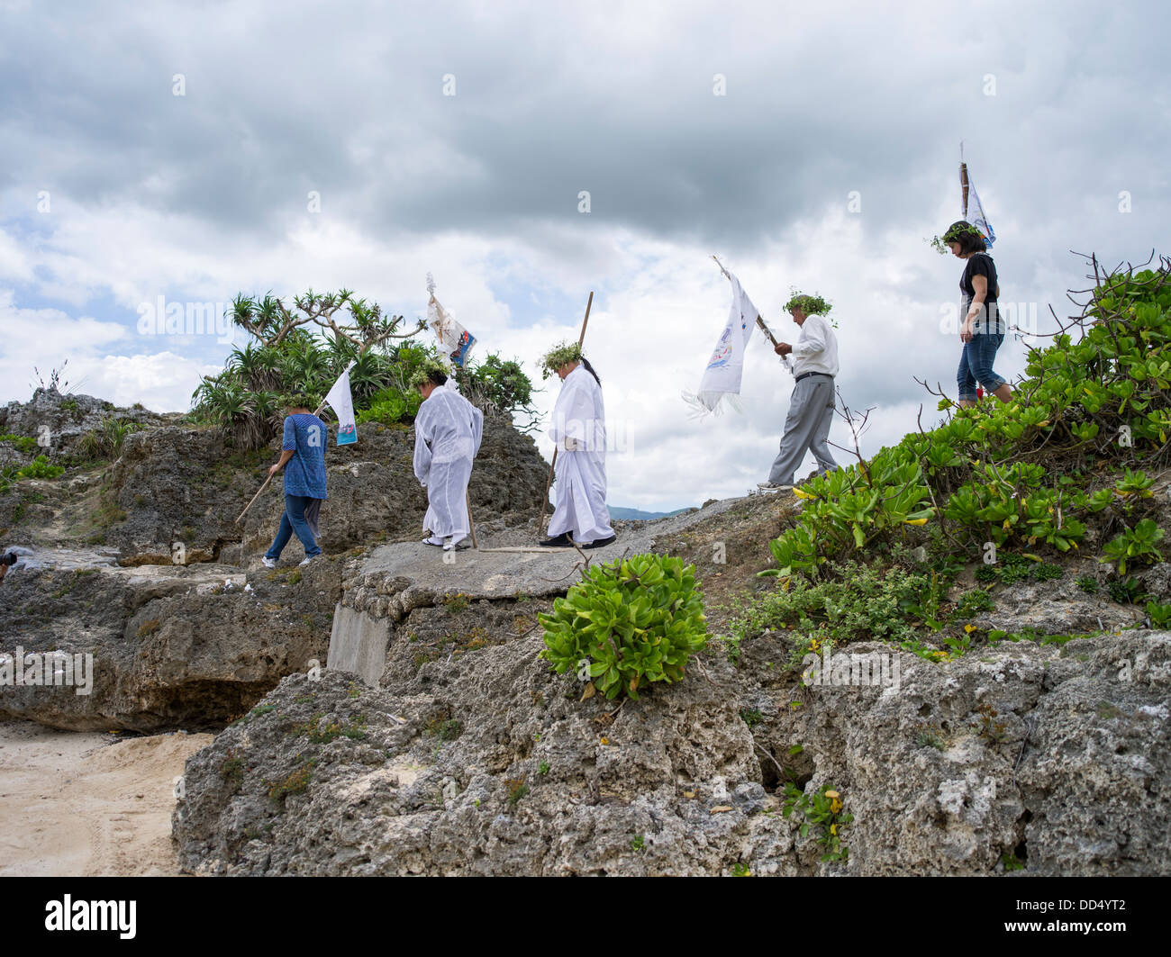 Los ancianos de la aldea hacen su camino a la playa que conduce las oraciones en Unjami Festival en Isla Kouri, Okinawa Foto de stock