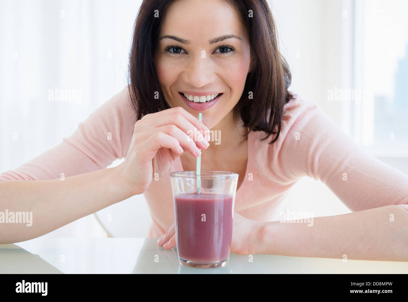 Mujer caucásica beber batido púrpura Foto de stock
