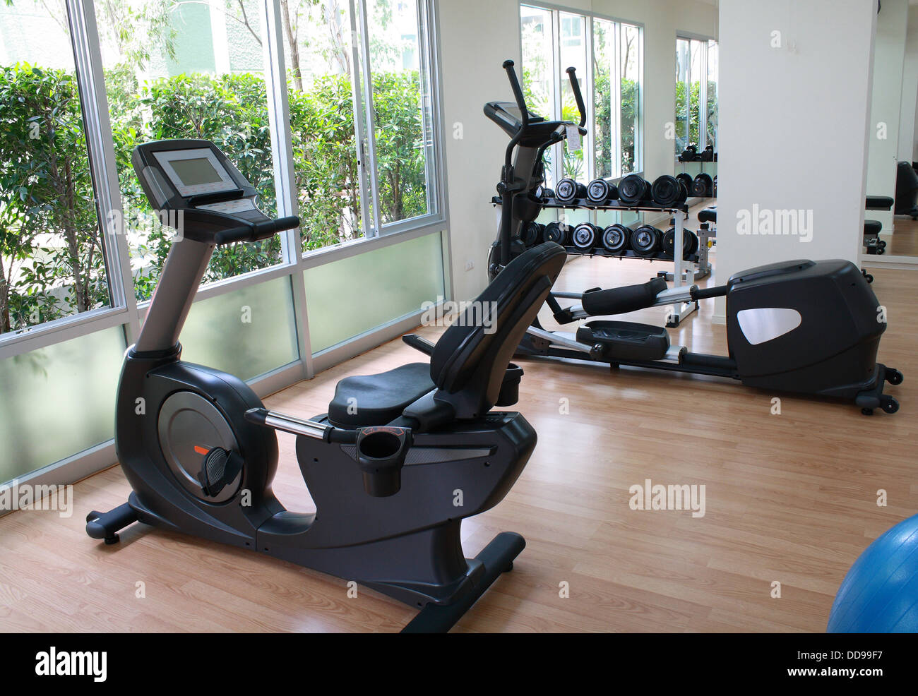 Equipos en la sala de fitness incluyen la cinta de correr, bicicleta estática, pesa y bola Foto de stock