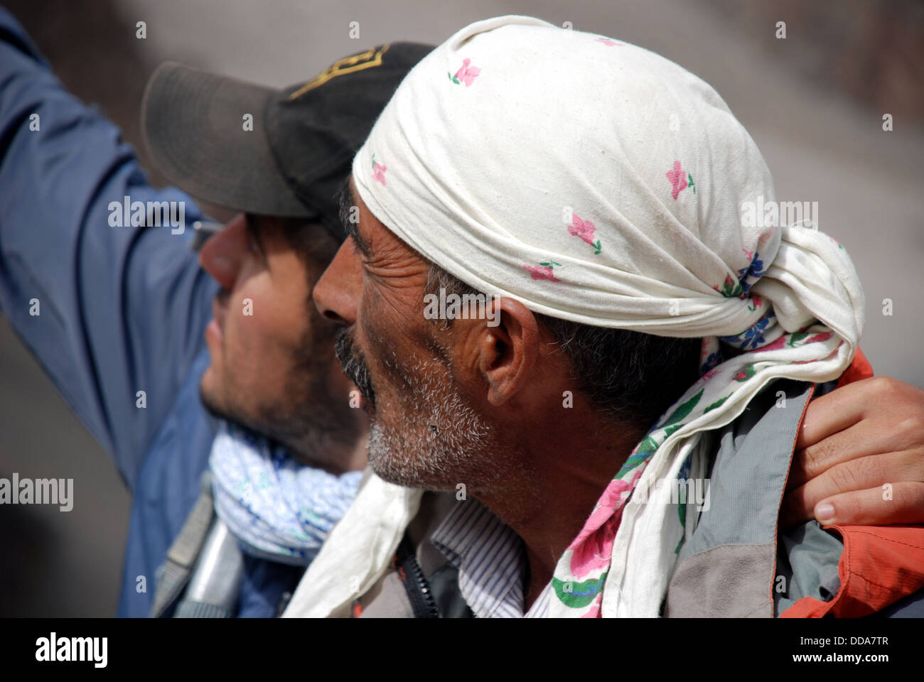 Un joven señala un objeto de interés para su anciano compañero de fann montañas de Tayikistán Foto de stock