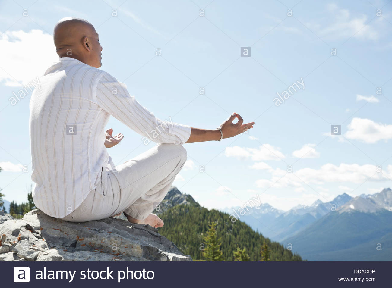 Hombre maduro, meditando en la cima de la montaña Foto de stock