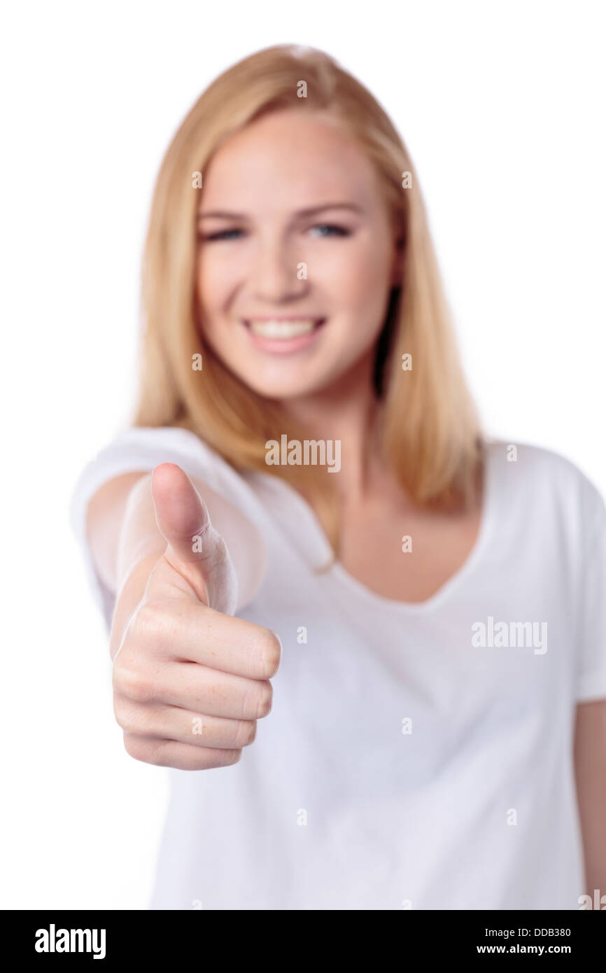 Mujer sonriente dando un Thumbs up gesto de aprobación, acuerdo y éxito con enfoque a su mano y someras dof Foto de stock