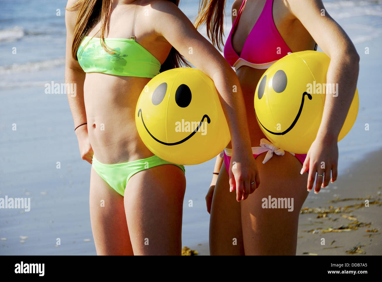 Chica 13, niña de 18 años de pie en la playa celebración sonrisa pelotas de  playa Fotografía de stock - Alamy