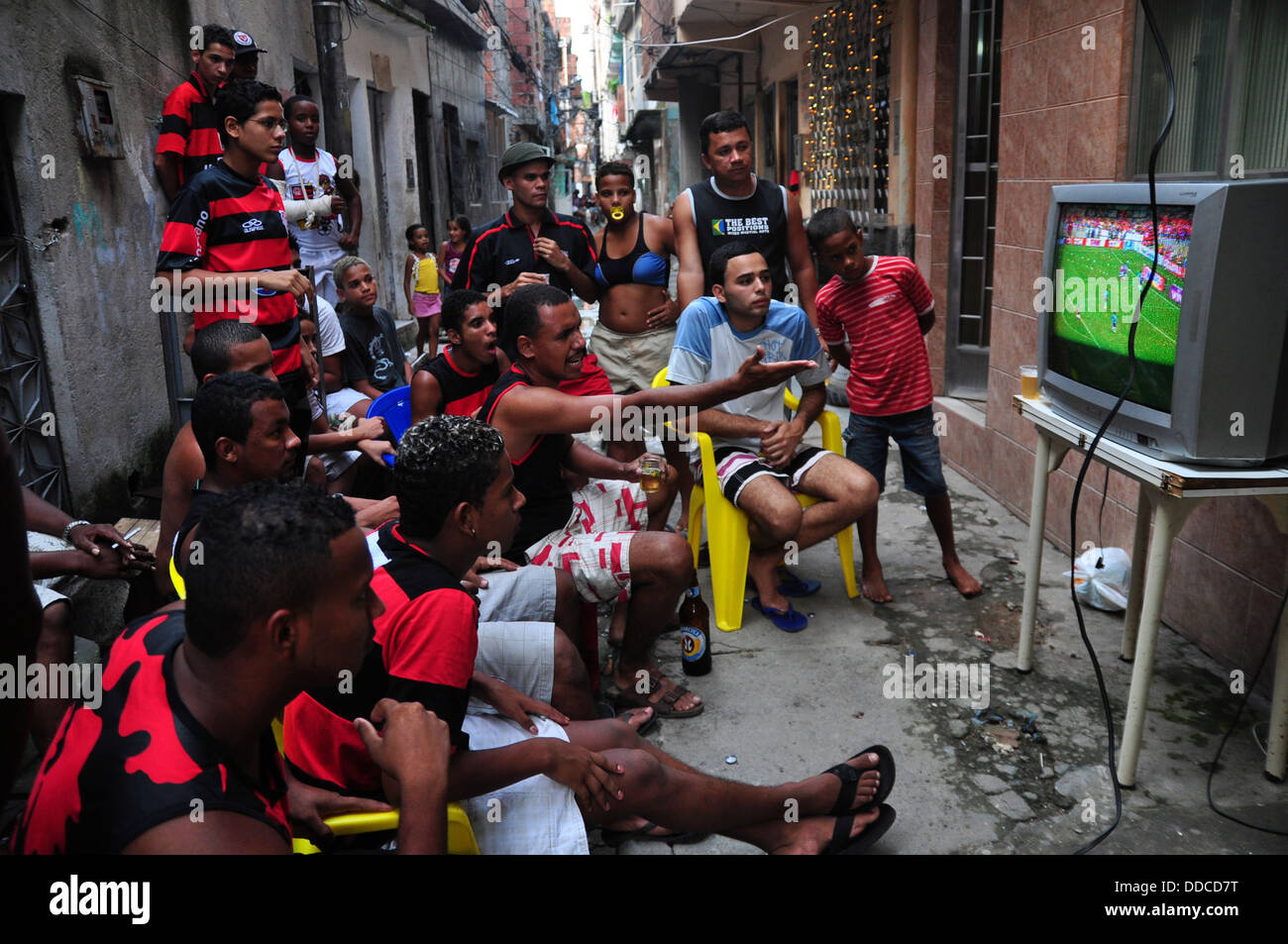 Ventiladores Flamego ver partido de por televisión en una favela da Mare alley. Río de Janeiro, Brasil Fotografía de stock -