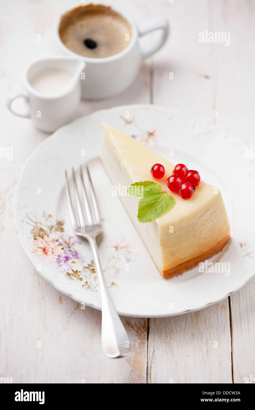 Cheesecake con grosellas con café en la placa Foto de stock