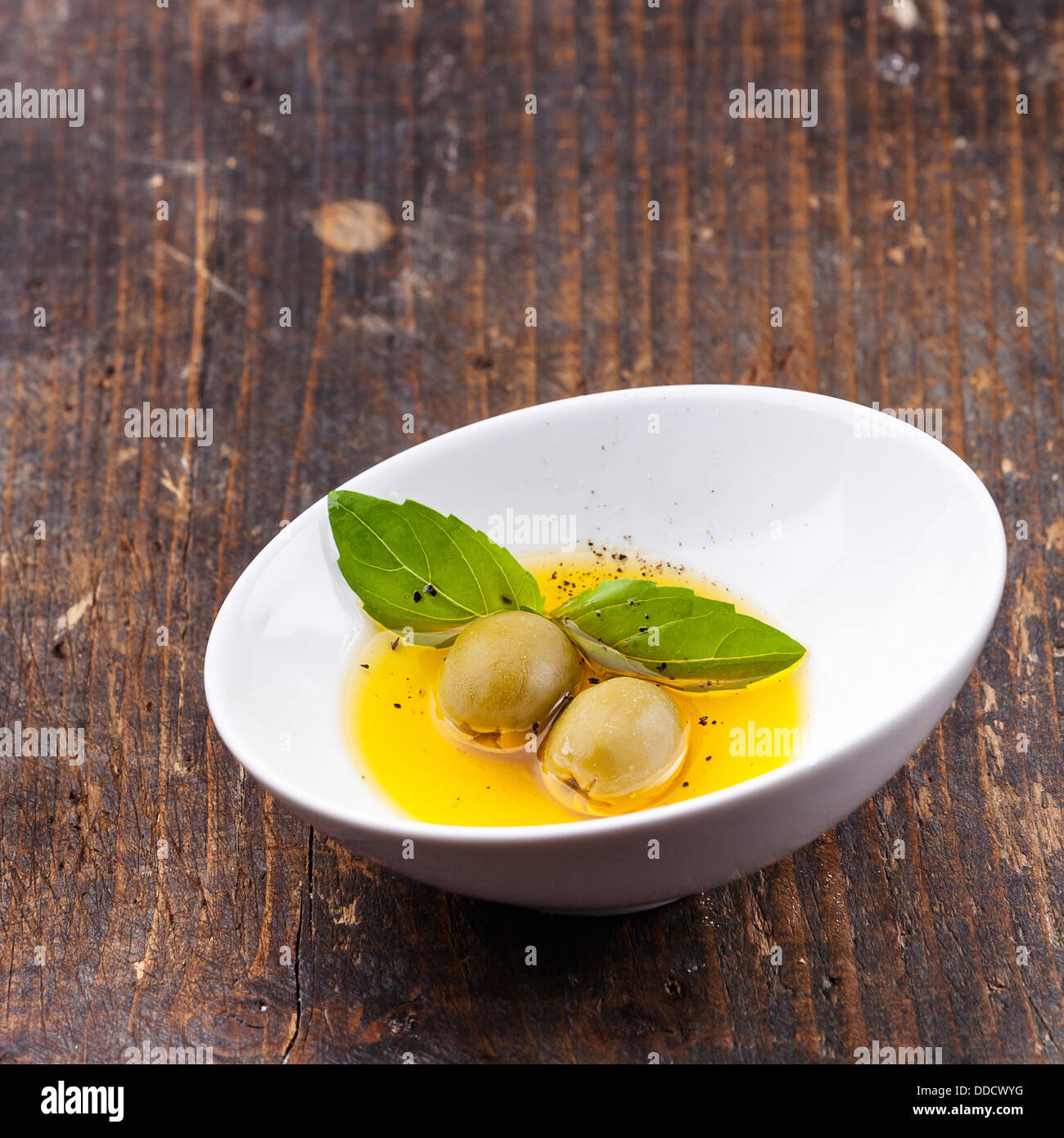Las aceitunas y el aceite de oliva en un tazón Foto de stock