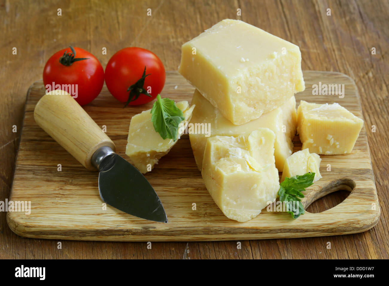 Queso parmesano natural duro sobre una tabla de madera Foto de stock