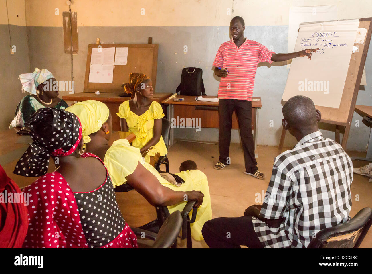 Las microfinanzas. Las mujeres que reciben instrucción en cómo estimar los costos de siembra y fertilización de un cultivo. Kaymor, Senegal Foto de stock