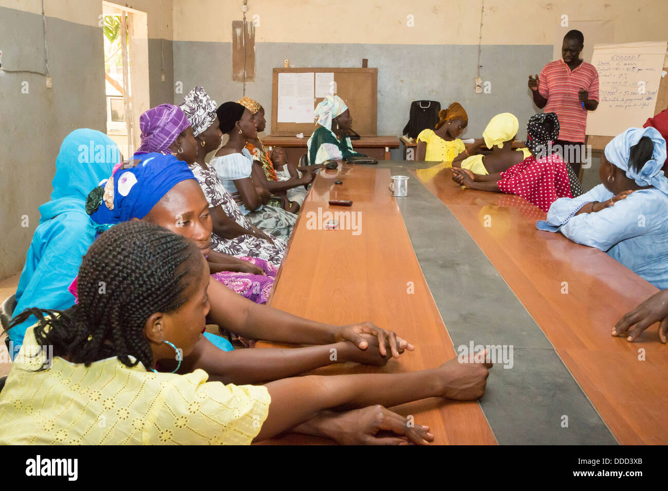 Las microfinanzas. Las mujeres que reciben instrucción en cómo estimar los costos de siembra y fertilización de un cultivo. Kaymor, Senegal Foto de stock