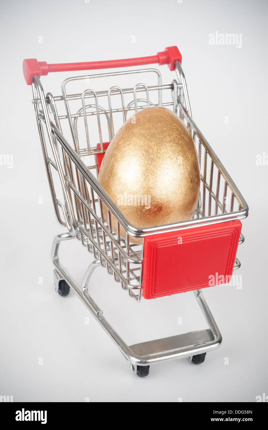 Un huevo de oro en el carrito de la compra Foto de stock