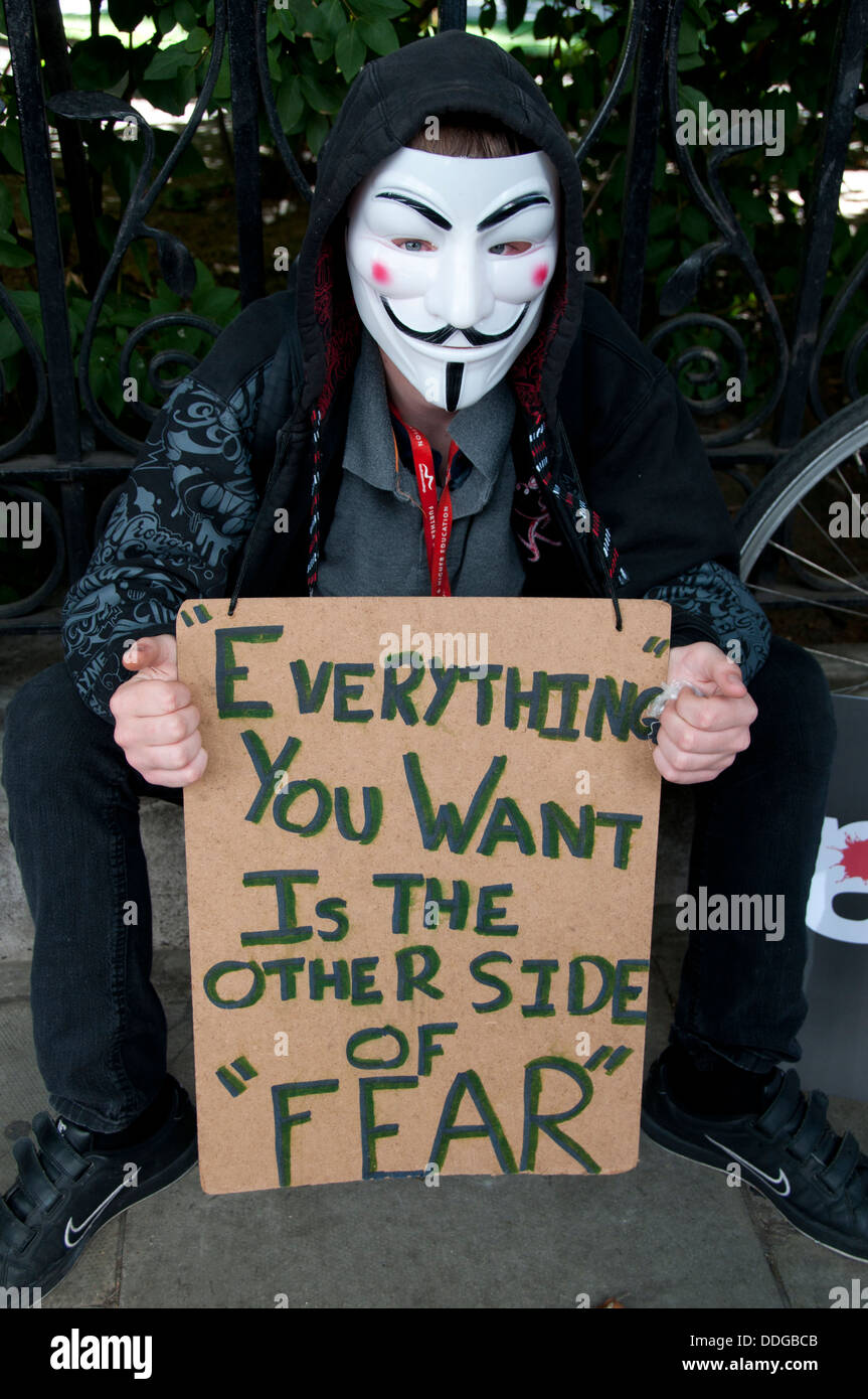 Un hombre que llevaba una máscara de V de Vendetta ,como llevado por ocupar los activistas, sostiene un cartel con Jack Canfield quote Foto de stock
