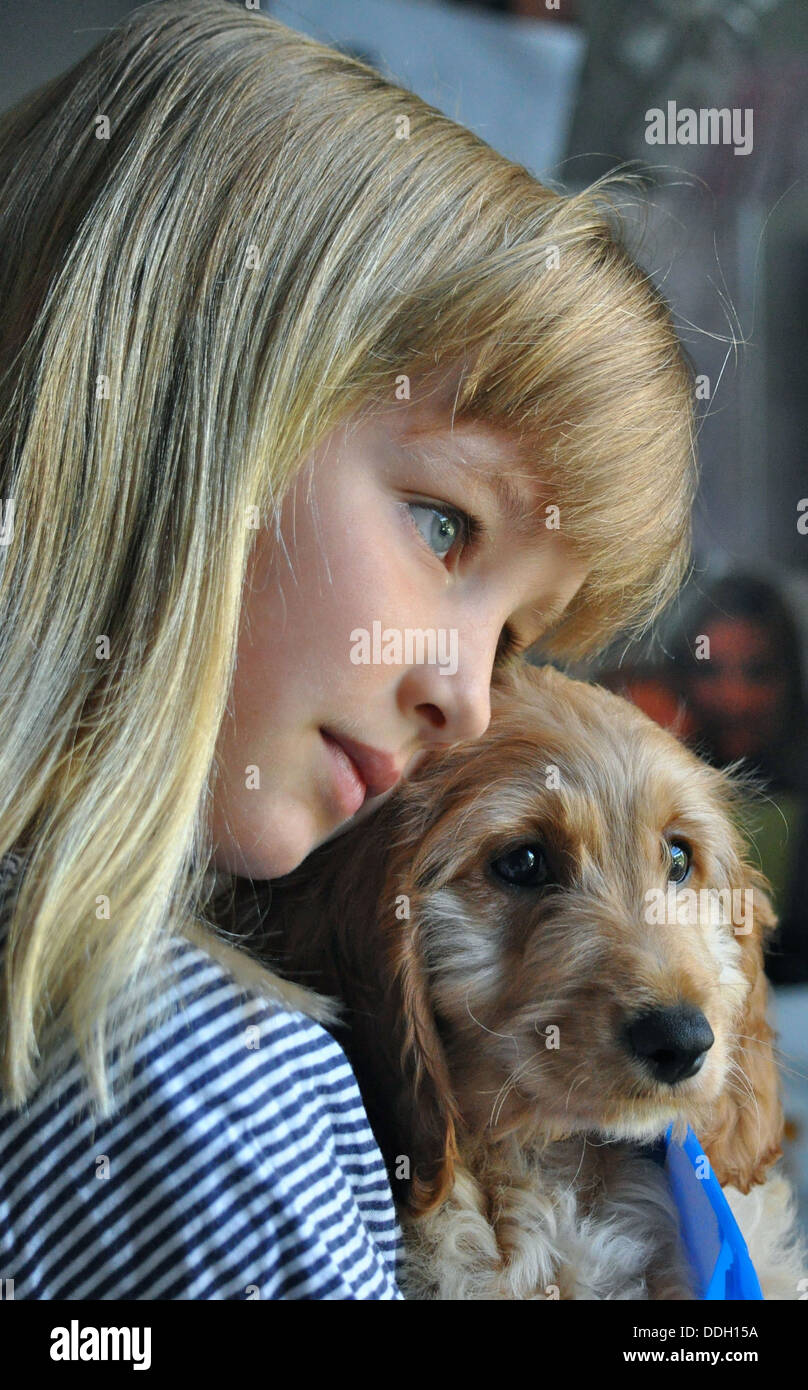 Bonita chica rubia abrazando a su cachorro Foto de stock