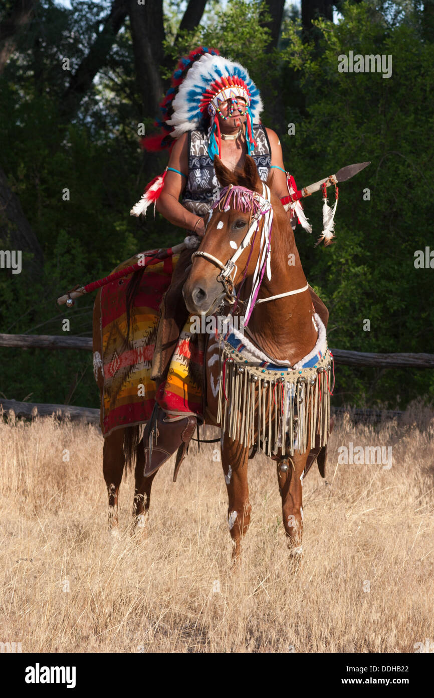 Guerrero en Comanche vestido montando caballo castaño Foto de stock