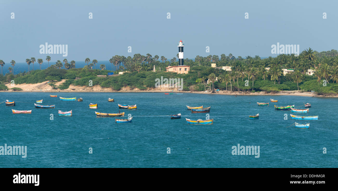 El paisaje costero con palmeras, faro y barcos de pesca Foto de stock