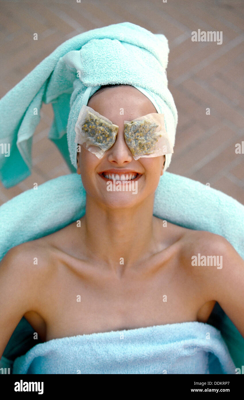 Mujer con bolsas de té de manzanilla en los ojos Fotografía de stock - Alamy