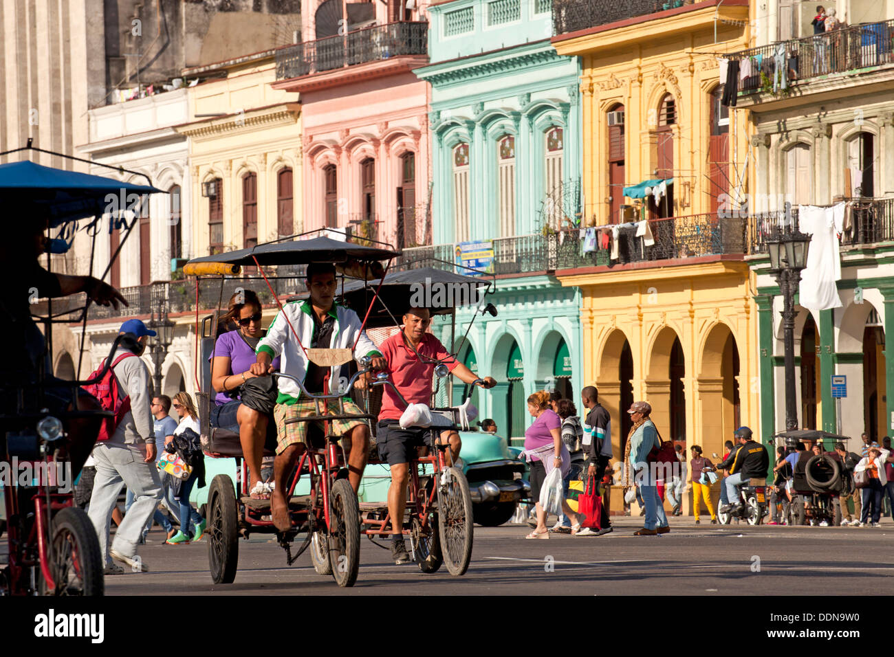 Taxi bicicletas y coloridos edificios en el centro de La Habana, Cuba, El Caribe Foto de stock