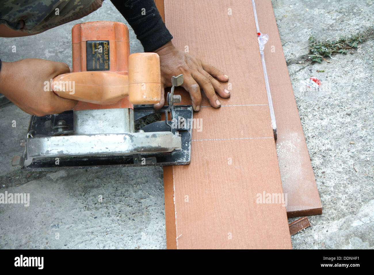 Los trabajadores están utilizando una sierra circular para cortar madera. Foto de stock