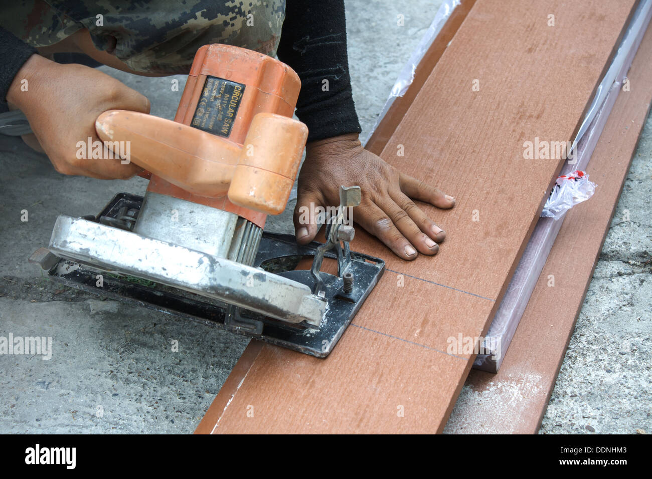 Los trabajadores están utilizando una sierra circular para cortar madera. Foto de stock
