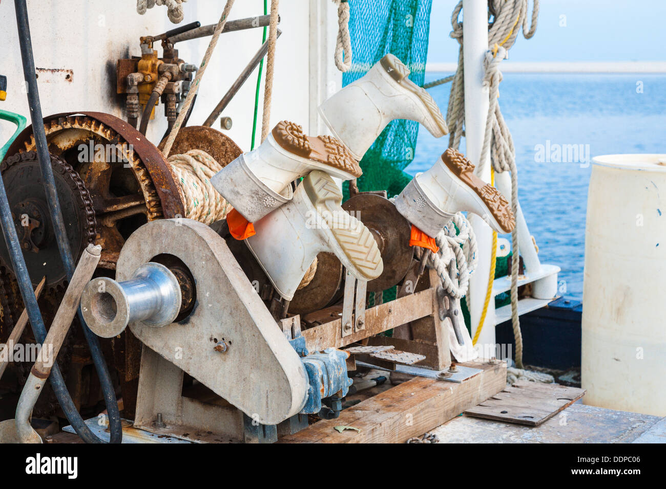 Wenches y botas de trabajo en un barco de pesca comercial en el pequeño puerto artesanal en Biloxi, Mississippi Foto de stock