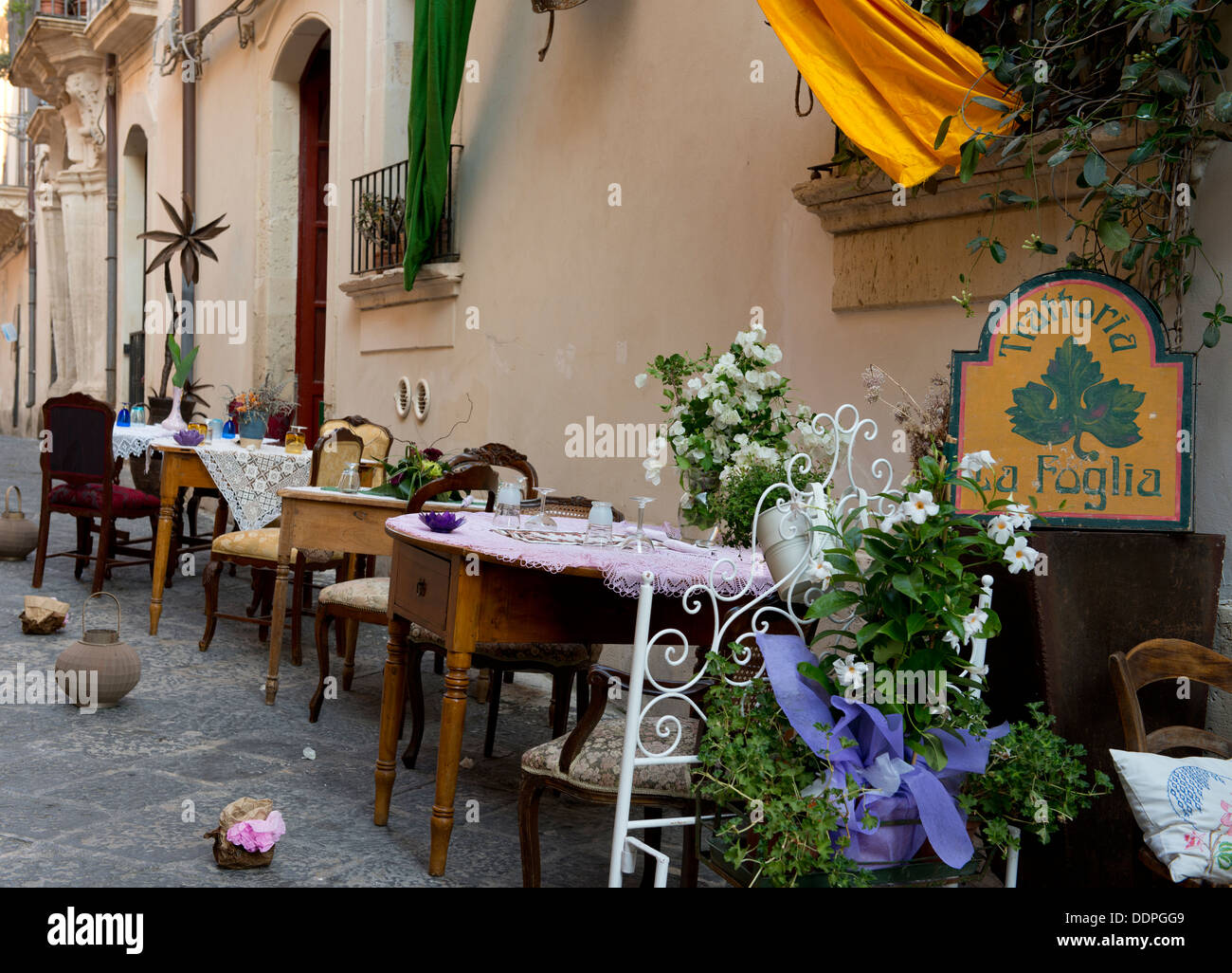 Trattoria La Foglia, un restaurante con mesas en la antigua calle de Ortigia, Siracusa, Sicilia, Italia Foto de stock