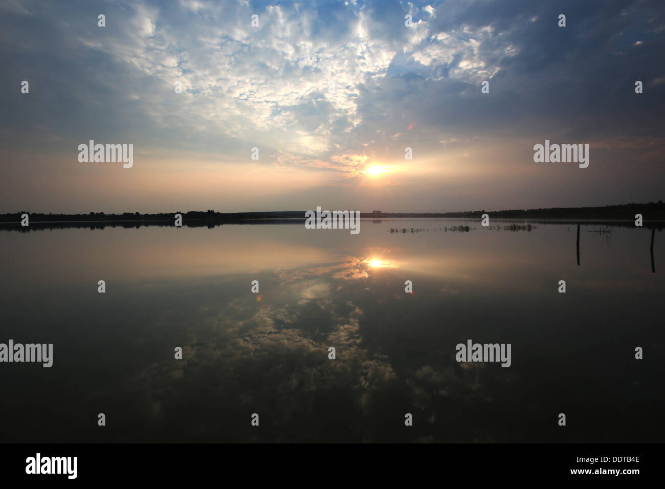 El sol se eleva por encima del lago Hainer Ver Kahnsdorf cerca de Leipzig en Alemania, el 31 de agosto de 2013. El lago fue creado en una antigua mina a cielo abierto de carbón blando en funcionamiento hasta 1993 y con 600 hectáreas de uno de los más grandes de la nueva lakescape de Leipzig. La inundación del sitio tuvo lugar desde 1999 hasta 2010. Foto: BERND WUESTNECK Foto de stock