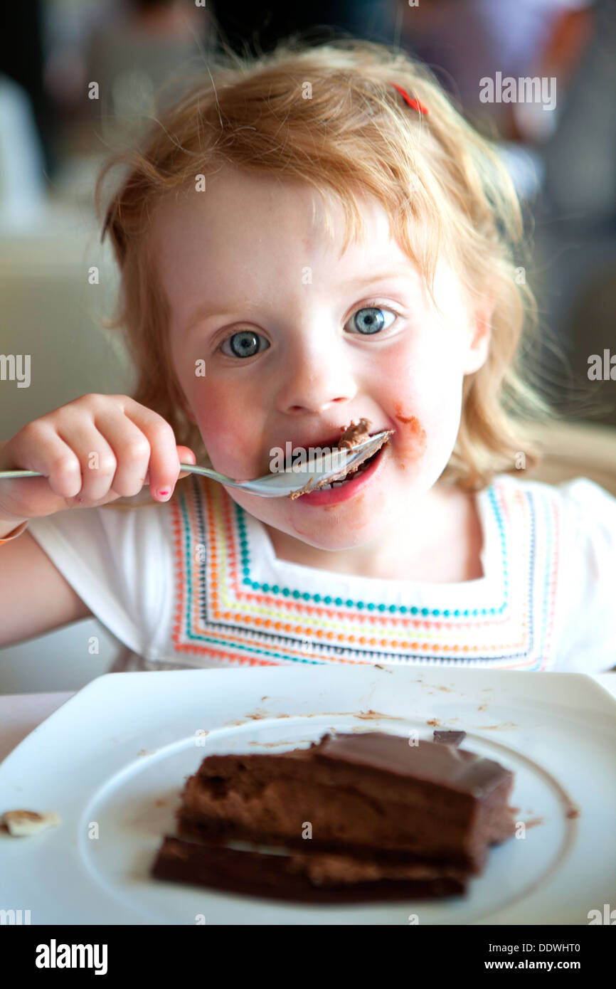 Niña comiendo pastel de chocolate fotografías e imágenes de alta resolución  - Alamy