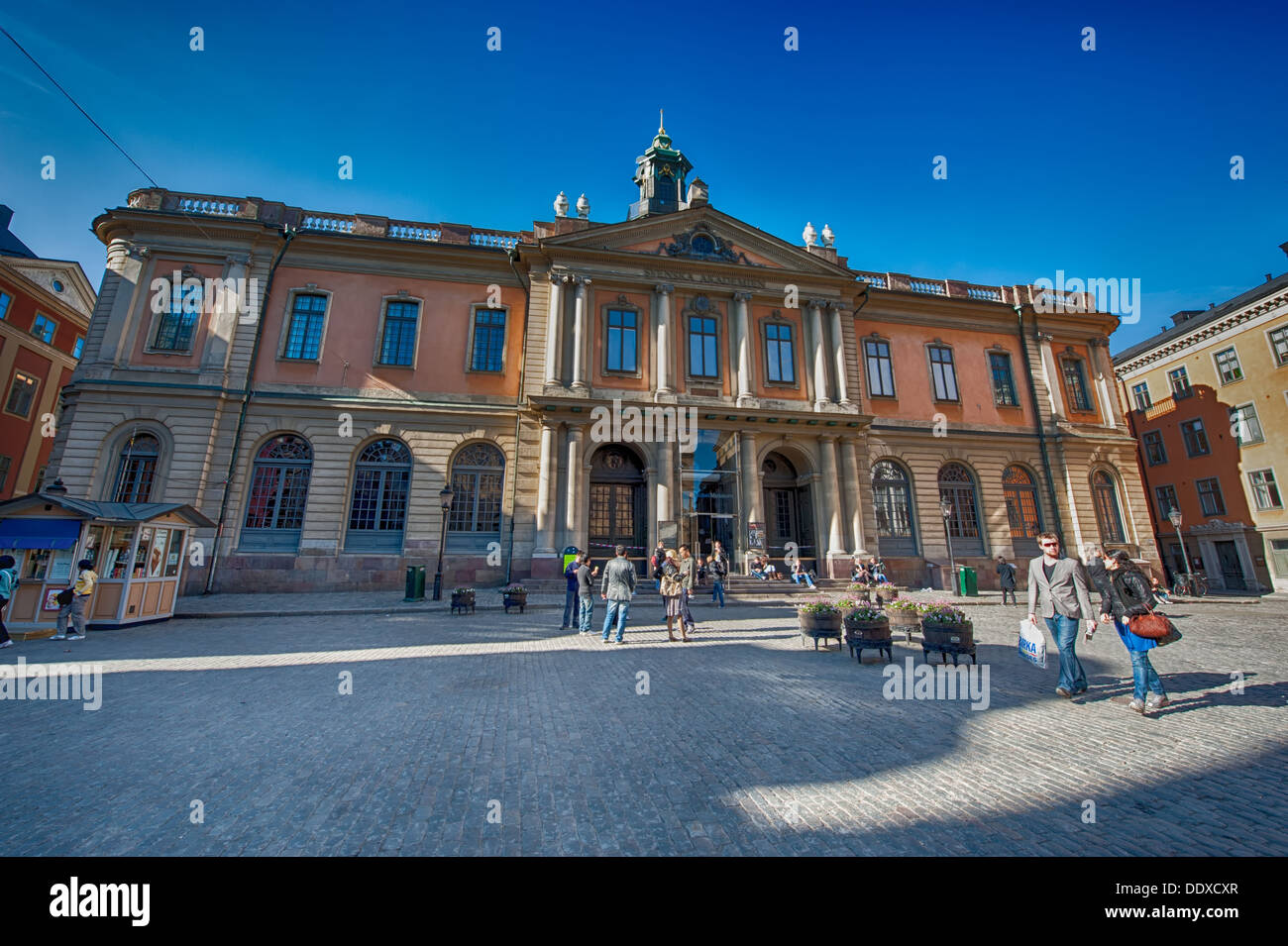 Los turistas admirar el edificio de la bolsa de Estocolmo. El edificio en el casco antiguo de la ciudad es el hogar de la academia sueca. Foto de stock