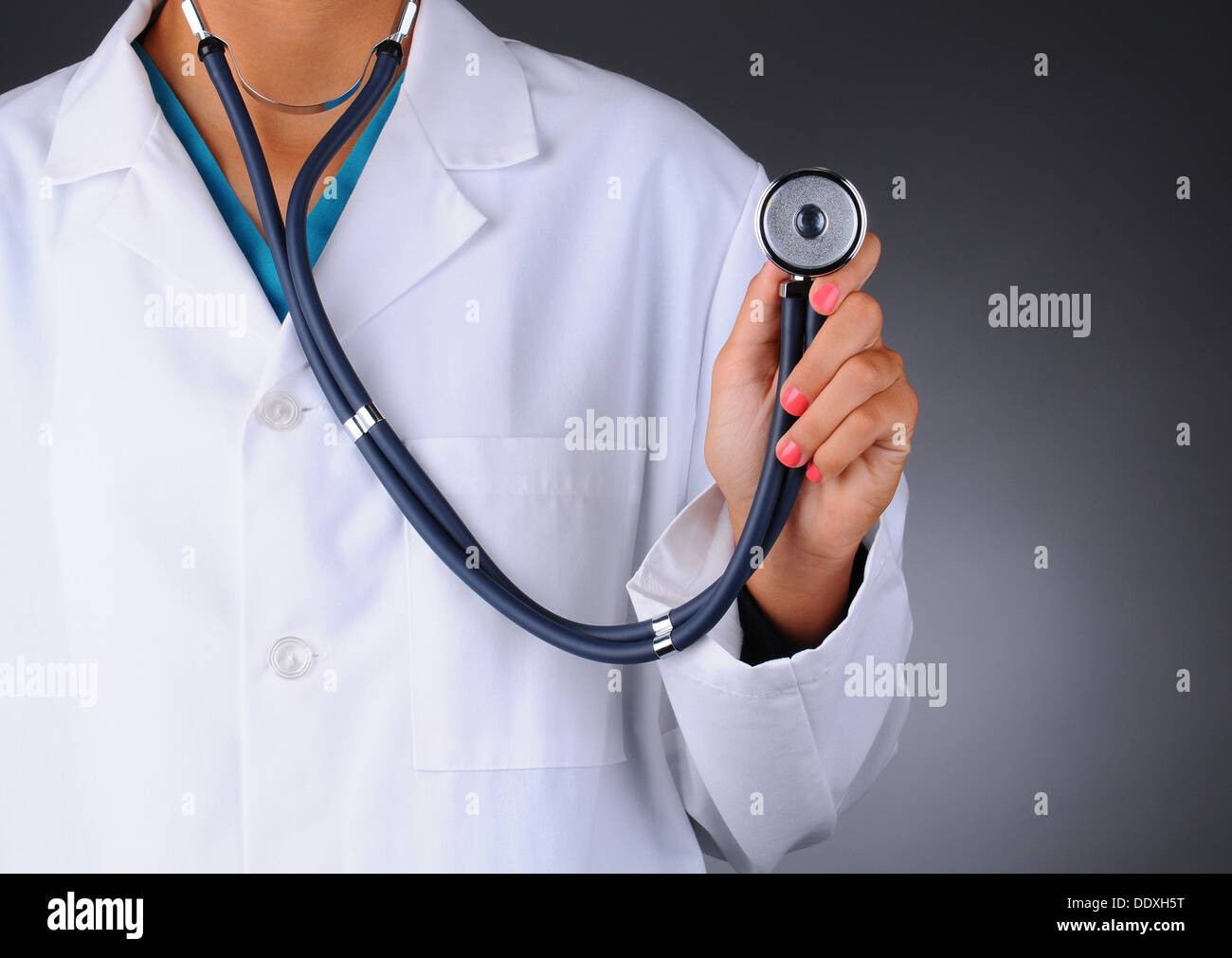 Primer plano de una enfermera o médico sosteniendo un estetoscopio mirando hacia la cámara. La mujer es irreconocible Foto de stock