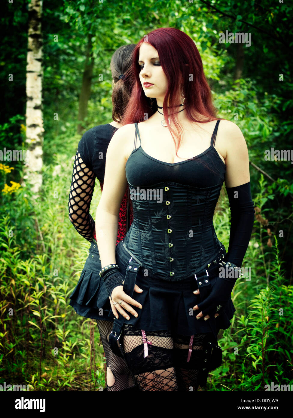 La mujer, vestida con un estilo gótico, de pie en un bosque Foto de stock