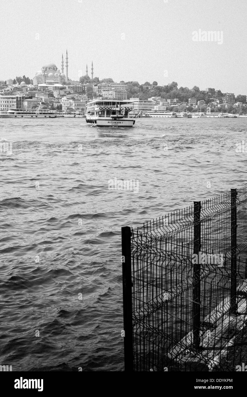 Excursión en barco por el Río Bósforo navegando hacia Estambul con una mezquita en el fondo Foto de stock