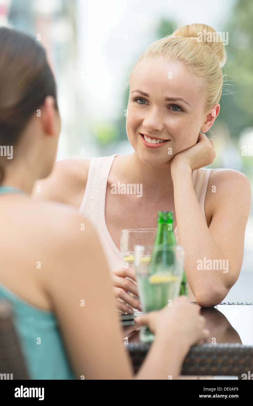 Las mujeres chatear y tener bebidas al aire libre Foto de stock