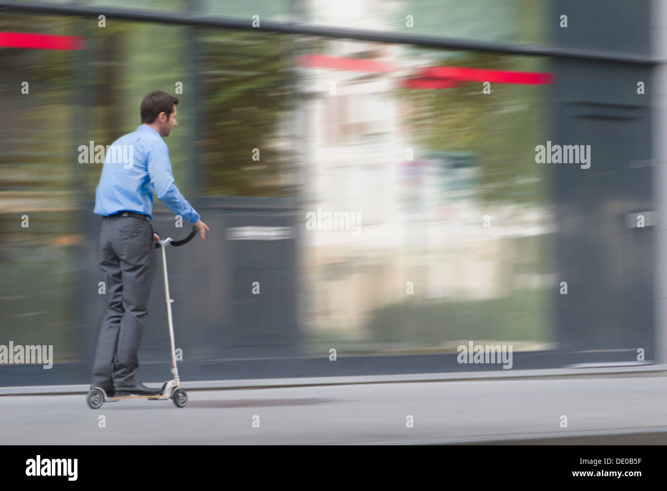 Hombre de negocios indumentaria hípica en push scooter Foto de stock