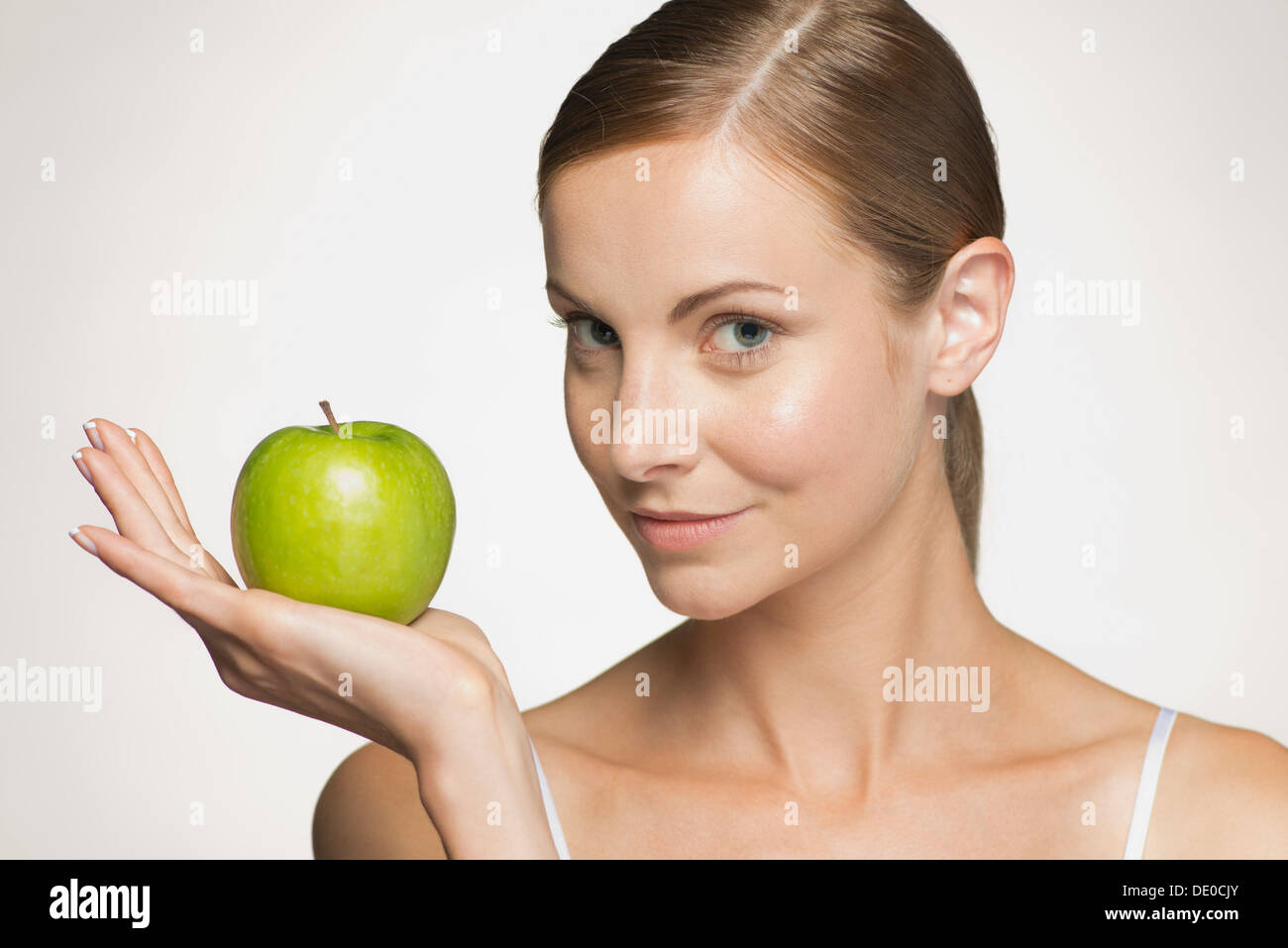 Mujer joven sosteniendo manzana verde Foto de stock