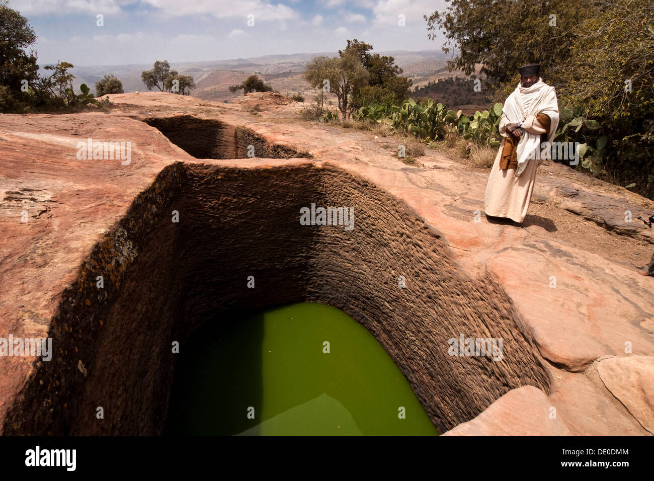 Los monjes ortodoxos en el agua santa cerca de la roca labrada a iglesia de Mikael Imba Foto de stock