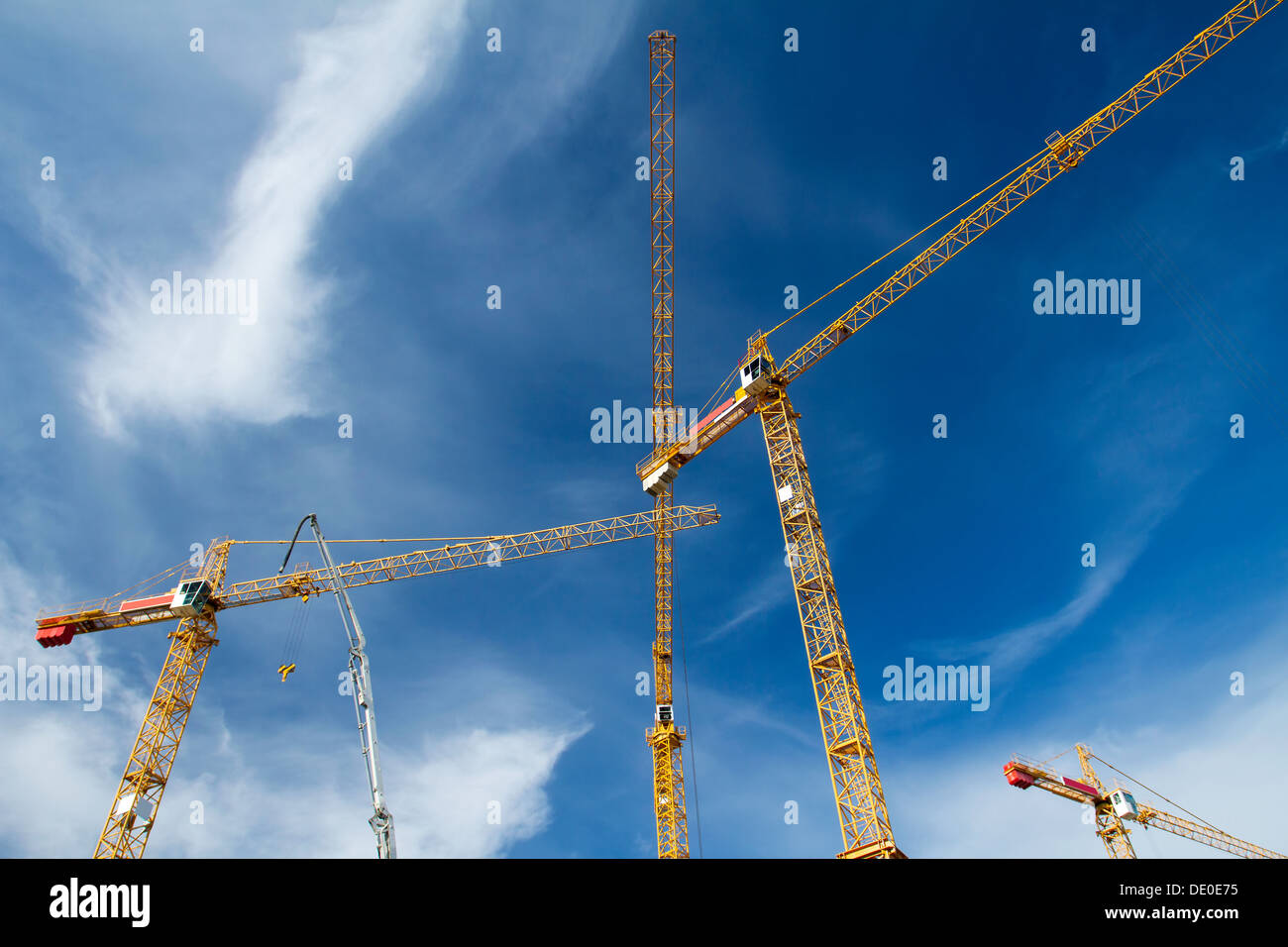 Grúas de construcción contra el cielo azul Foto de stock